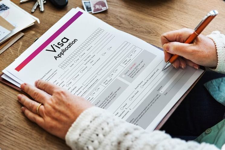Person filling out visa application form for Canadian Federal Skilled Worker program