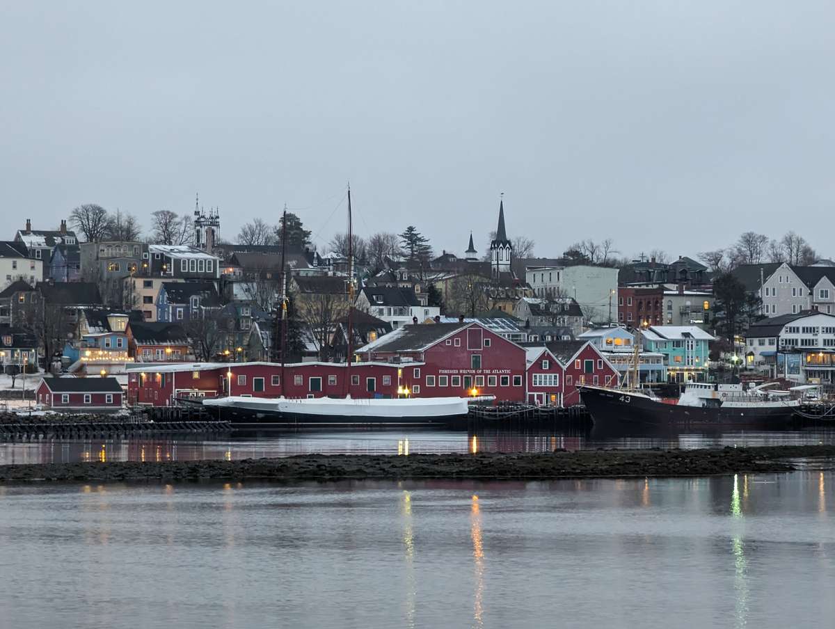 Historic red buildings and boats along the waterfront harbor of Lunenburg, Nova Scotia.