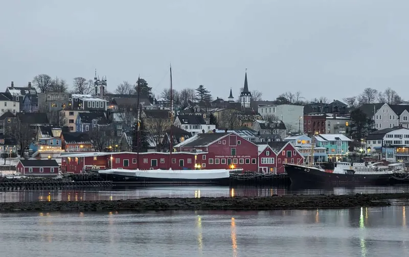 Historic red buildings and boats along the waterfront harbor of Lunenburg, Nova Scotia.