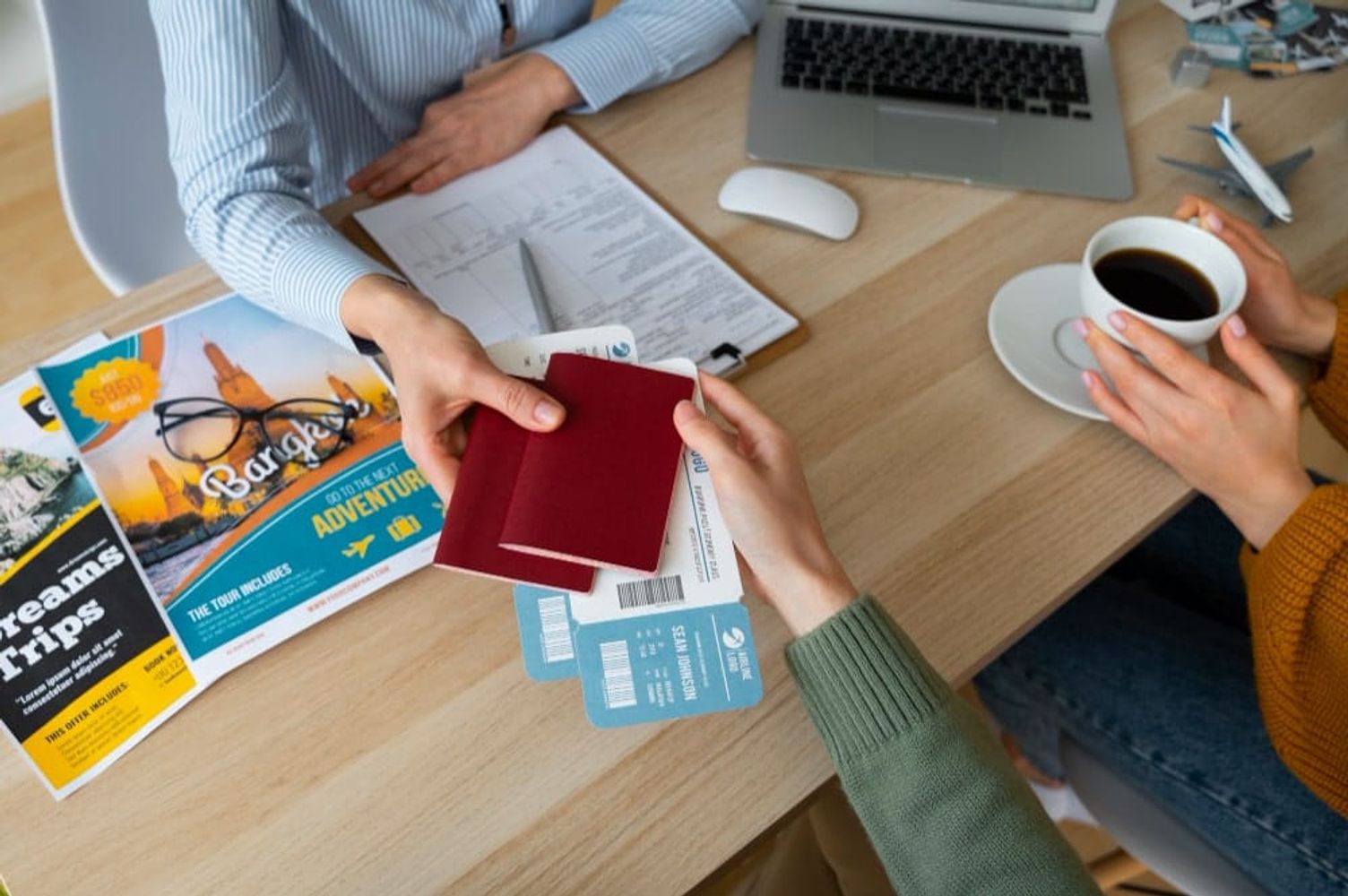 Handing over passports and boarding passes at a travel agency desk