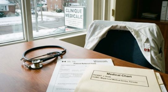 A stethoscope resting on a desk beside official documents in a Canadian medical clinic