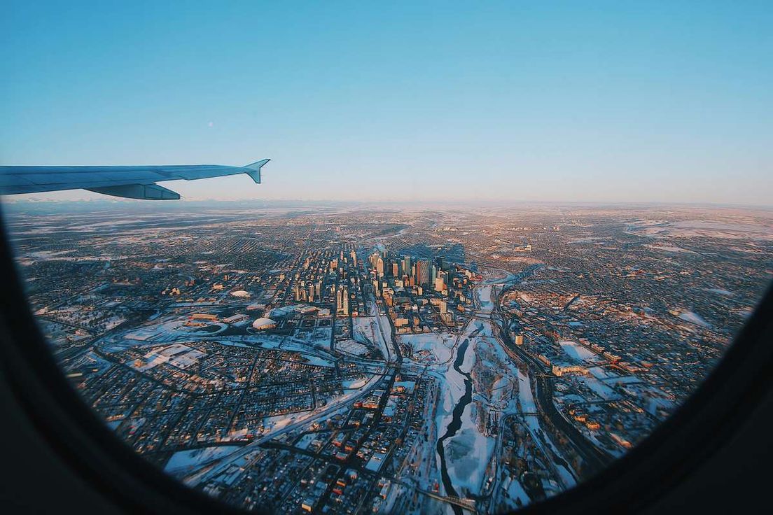 Aerial view of Calgary's snow-covered skyline from an airplane window.