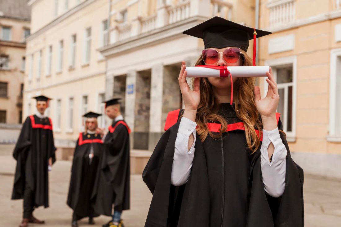 International student celebrating graduation with diploma – Post-Graduate Work Permit in Canada