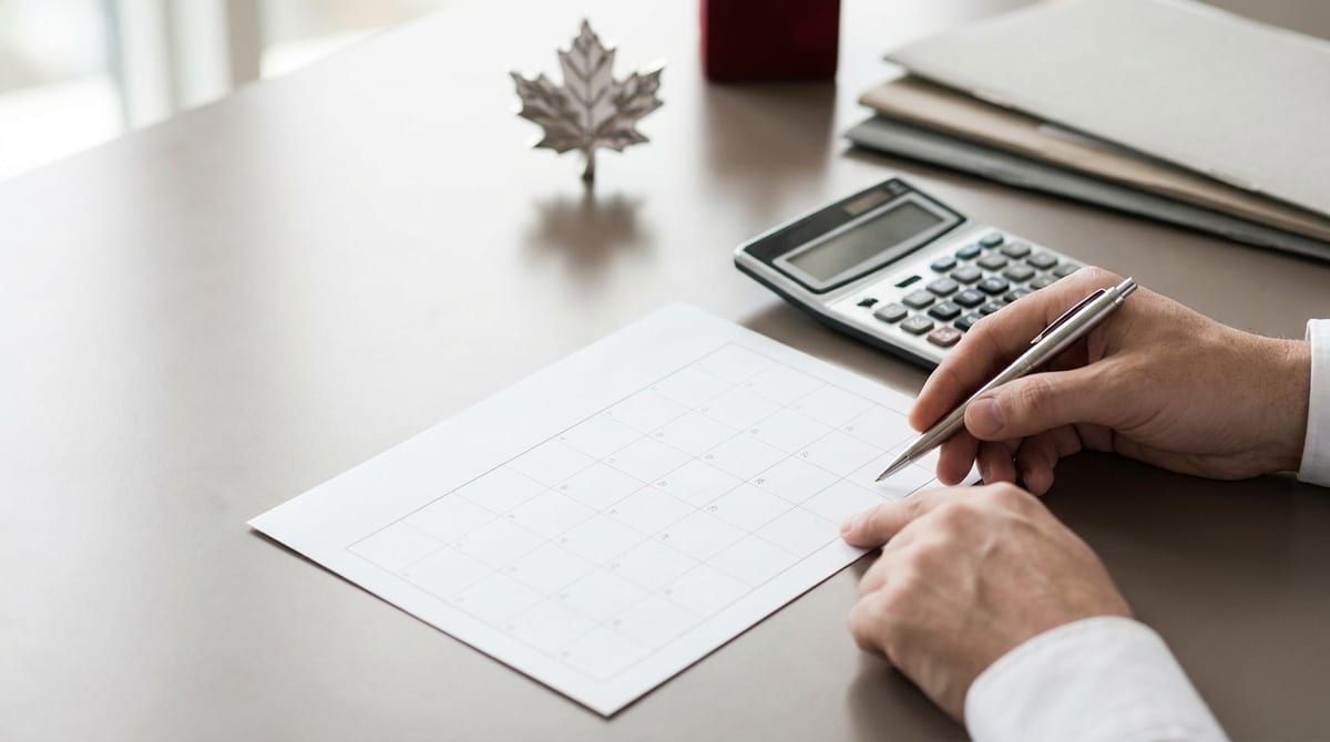 Hands using a calculator and calendar on a professional office desk, calculating Canadian citizenship eligibility days.
