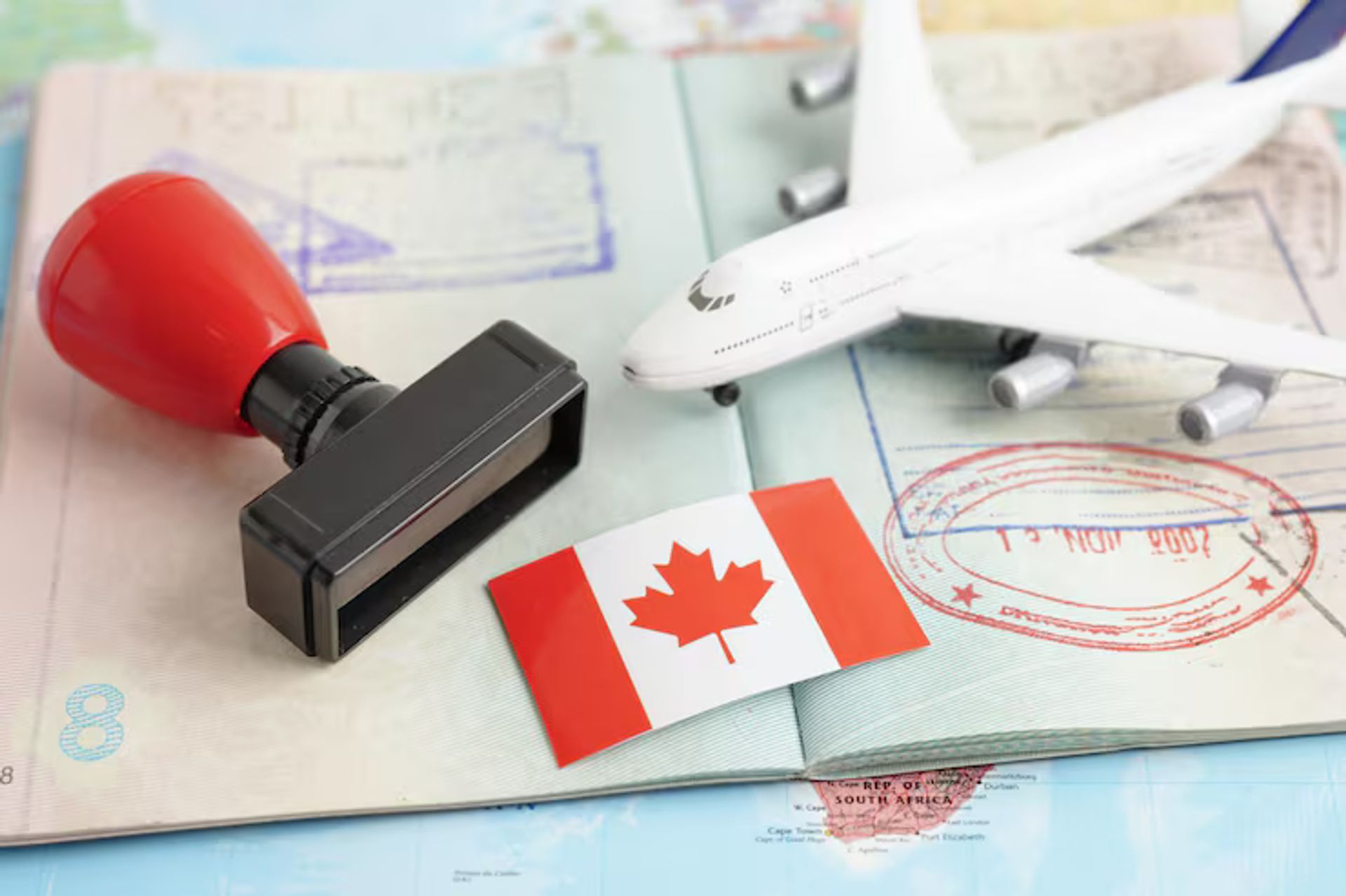 Passport with a stamp, Canada flag, and a plane figure on top of it