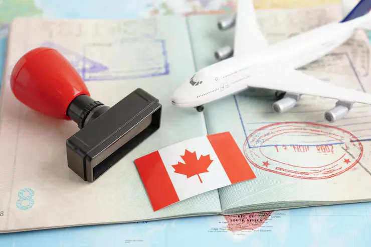 Passport with a stamp, Canada flag, and a plane figure on top of it