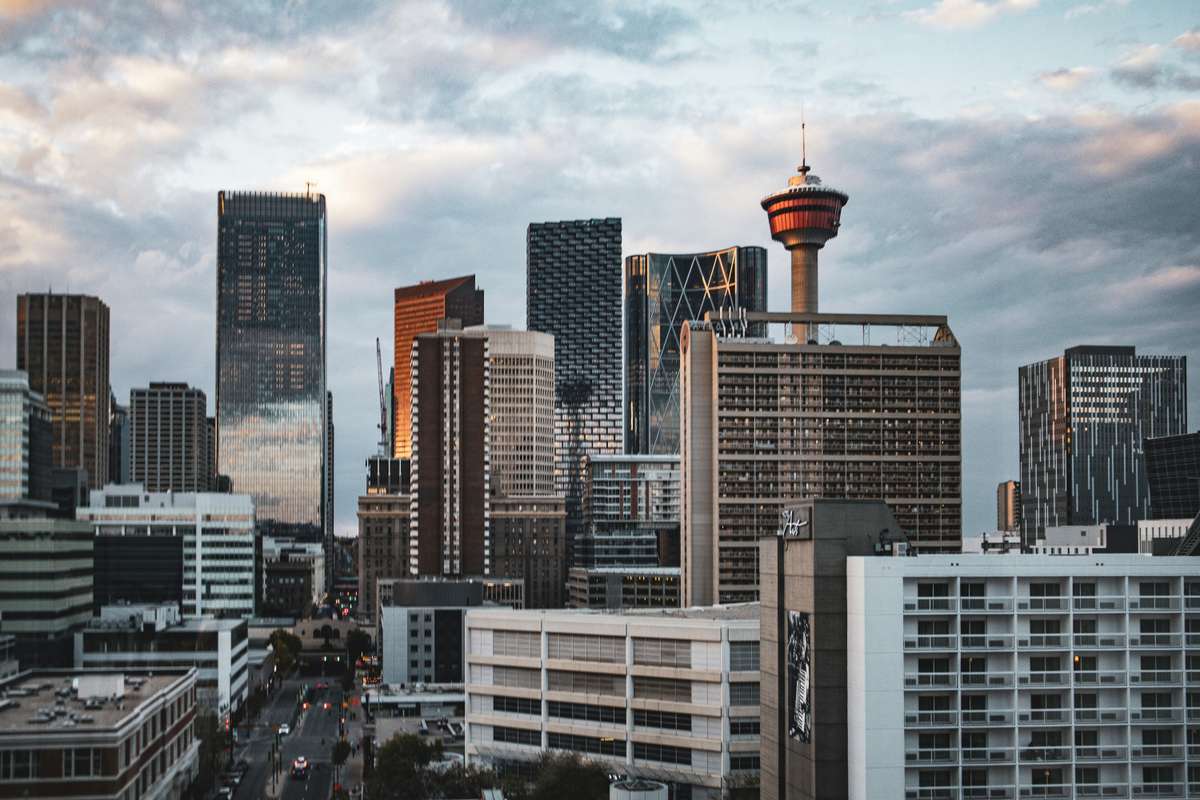 Downtown Calgary skyline featuring tall skyscrapers and the Calgary Tower under a cloudy sky.