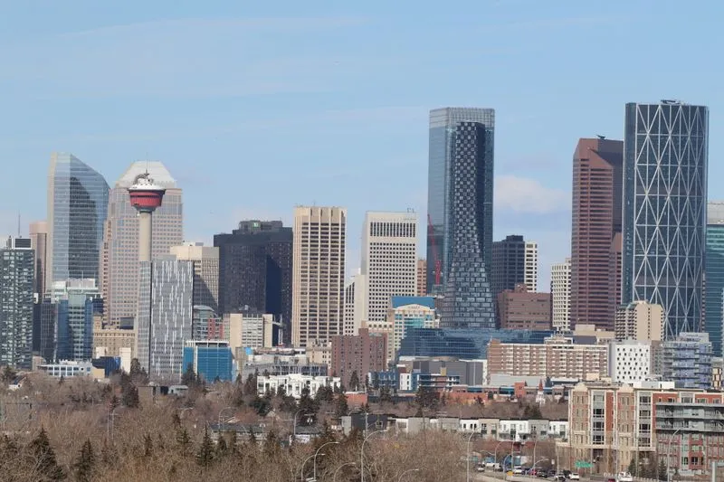 Downtown Calgary skyline featuring the Calgary Tower and skyscrapers under a blue sky.