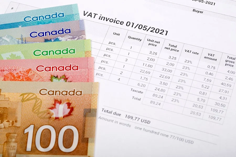 five Canadian dollar bills on a VAT invoice