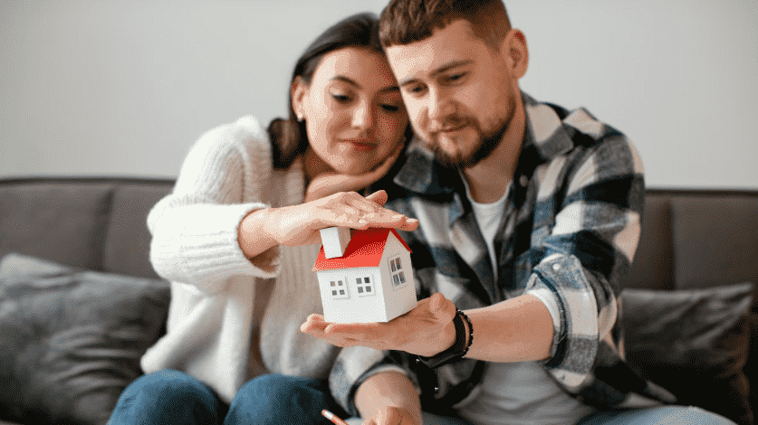 a family with house maket in their hand