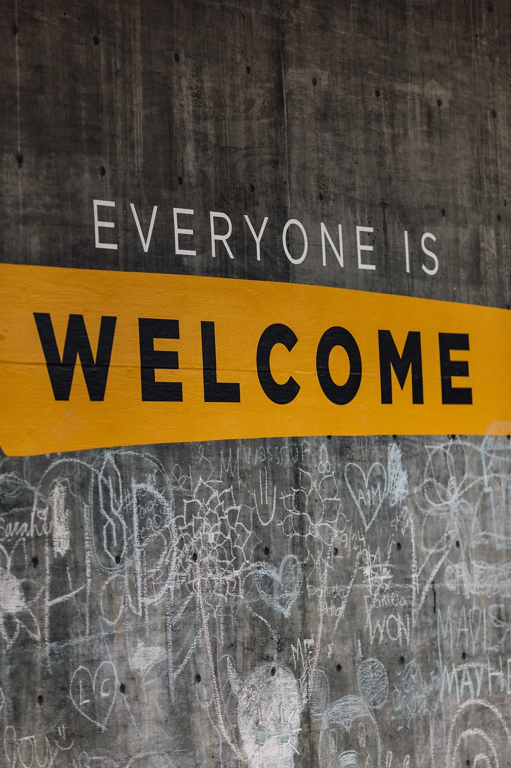 graffiti on a cement wall that says "everyone is welcome"