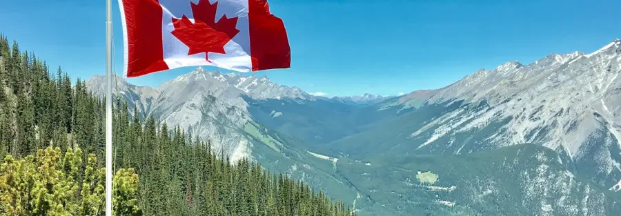 the Canadian flag on top of a green hill