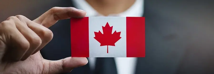 a man in a suit holding up a badge with the Canadian flag on it