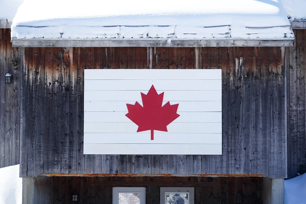 the Canadian symbol on a piece of wood on a cabin