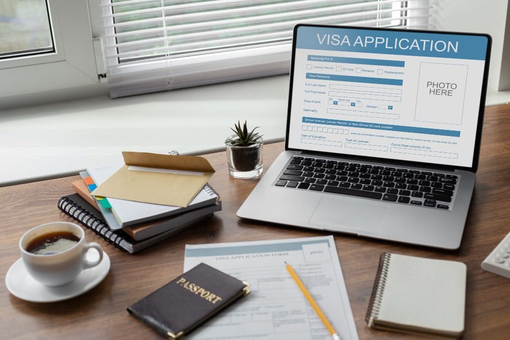 A laptop on the desk with a screen related to immigration.