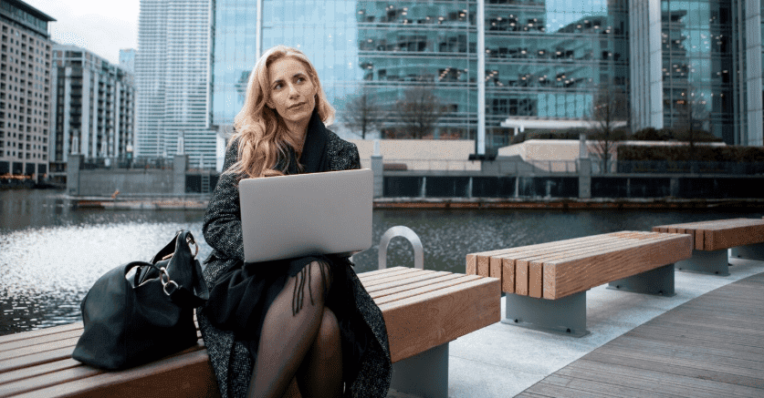 A woman sitting with a laptop in a Canadian city