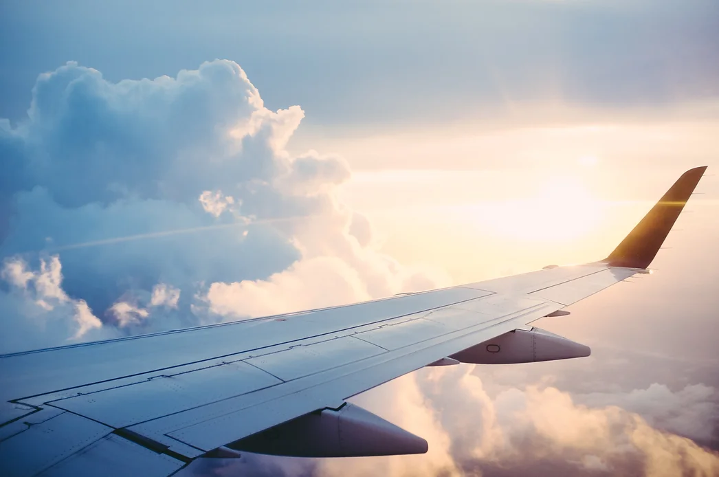 a view of the sky from inside an airplane with the right wing of the airplane being seen