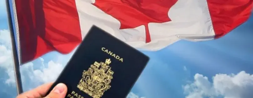 a Canadian passport held in front of the Canadian flag