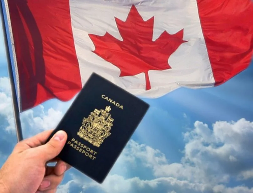 a Canadian passport held in front of the Canadian flag