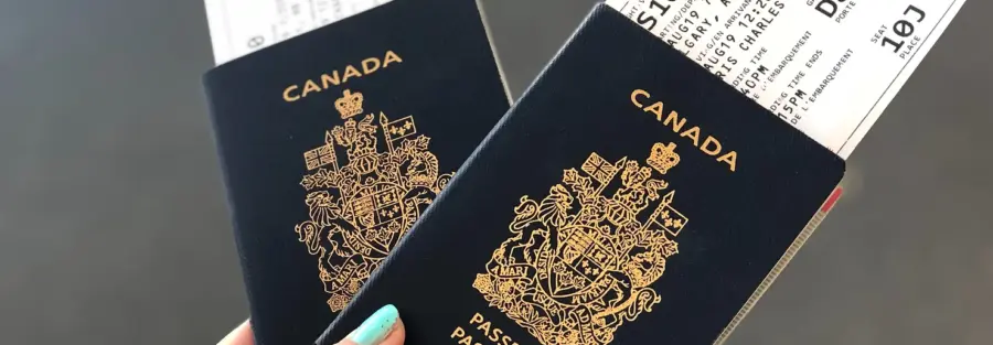 Two Canadian passports with flight tickets in them, held side by side