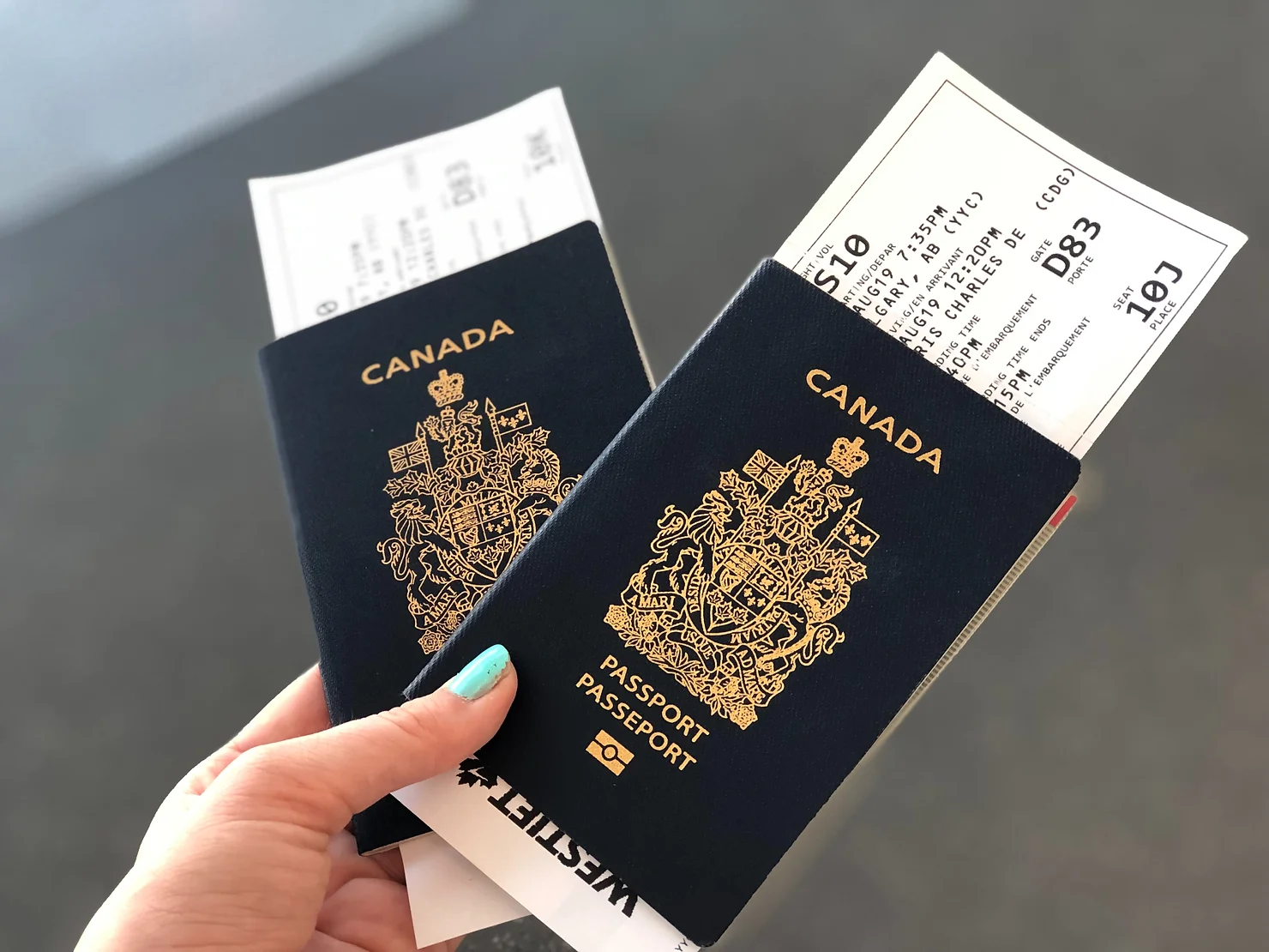 Two Canadian passports with flight tickets in them, held side by side