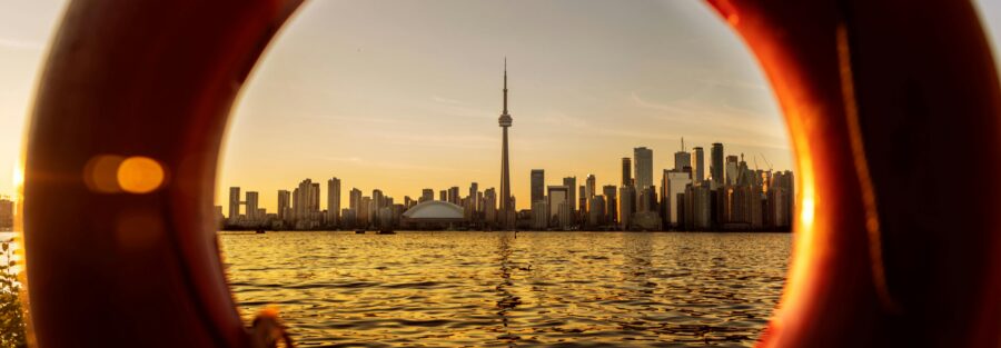 view of a toronto skyline at sunset framed through a lifebuoy ring