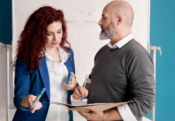 Immigration consultant discussing spousal sponsorship documents with a client in a professional setting.