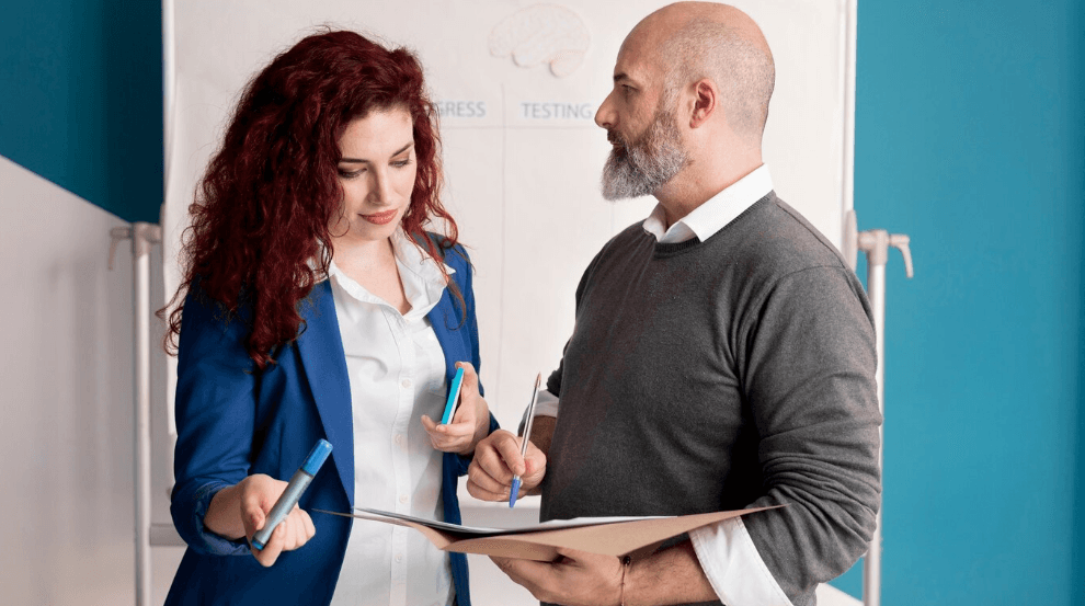 Immigration consultant discussing spousal sponsorship documents with a client in a professional setting.