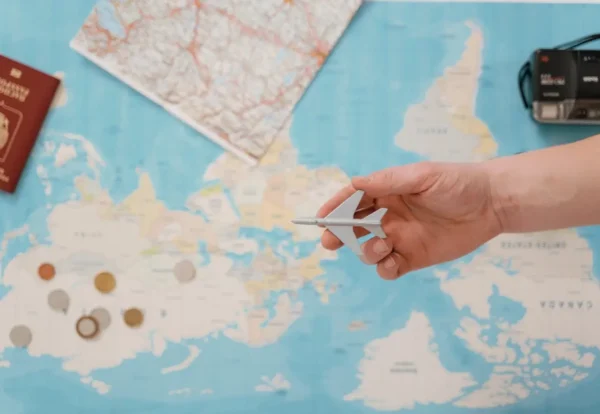 Hand holding toy airplane over world map