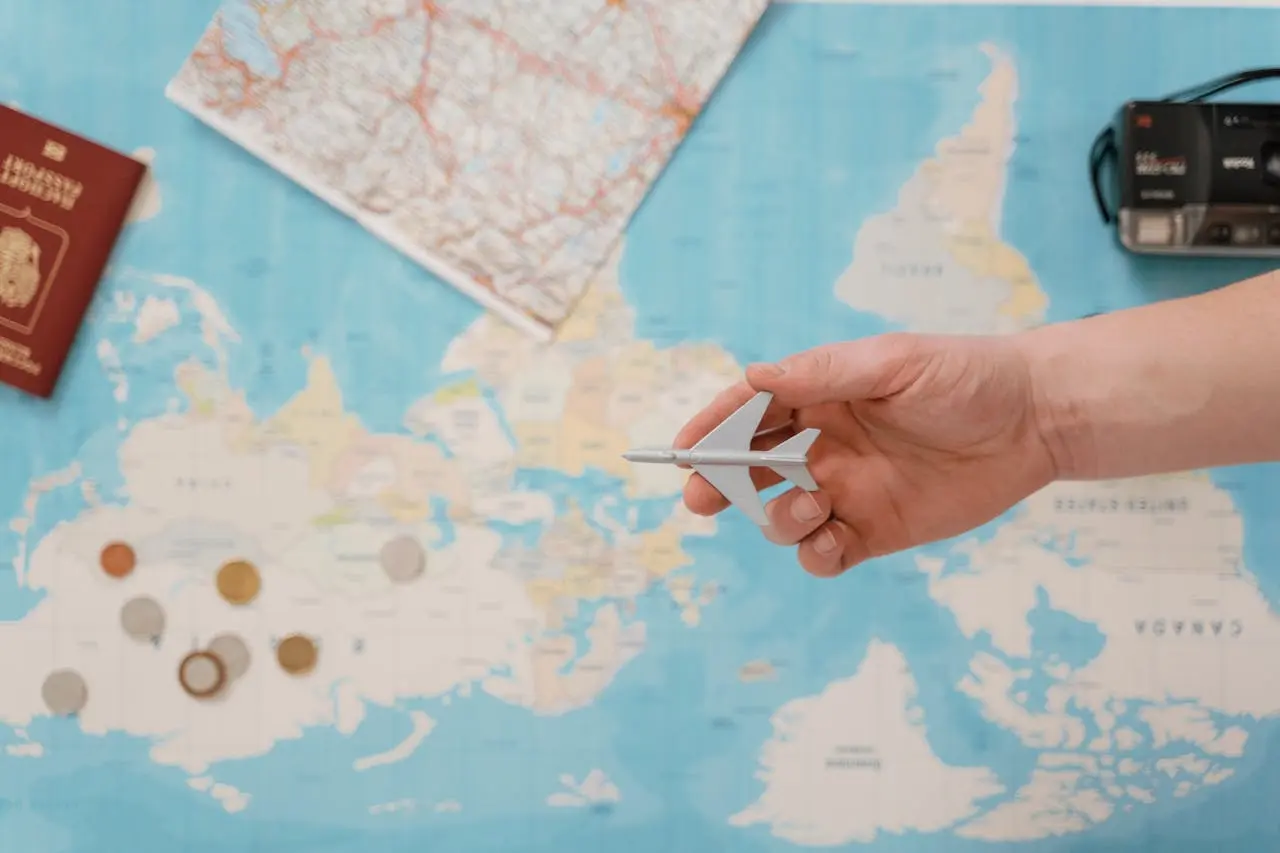 Hand holding toy airplane over world map
