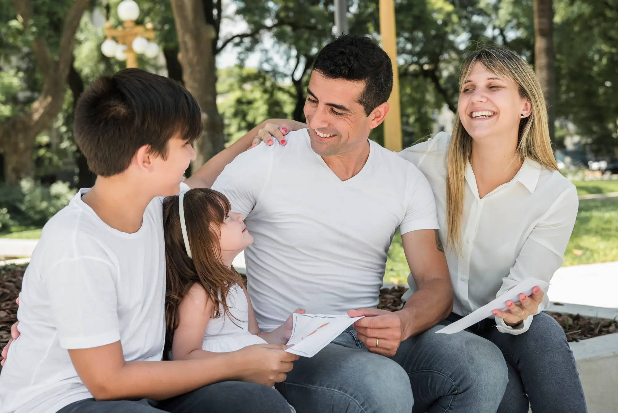 Smiling family sitting outdoors together – representing Canada Family Class Sponsorship program for immigration