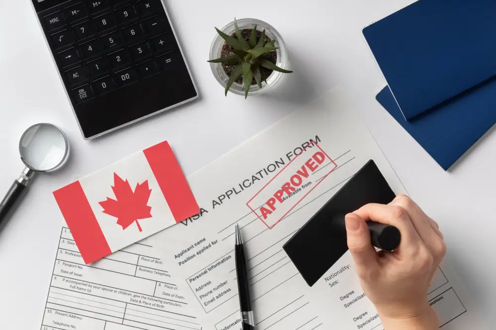 A Canadian visa application form stamped as approved, with a Canadian flag and a plant in the background, symbolizing success in the immigration process.