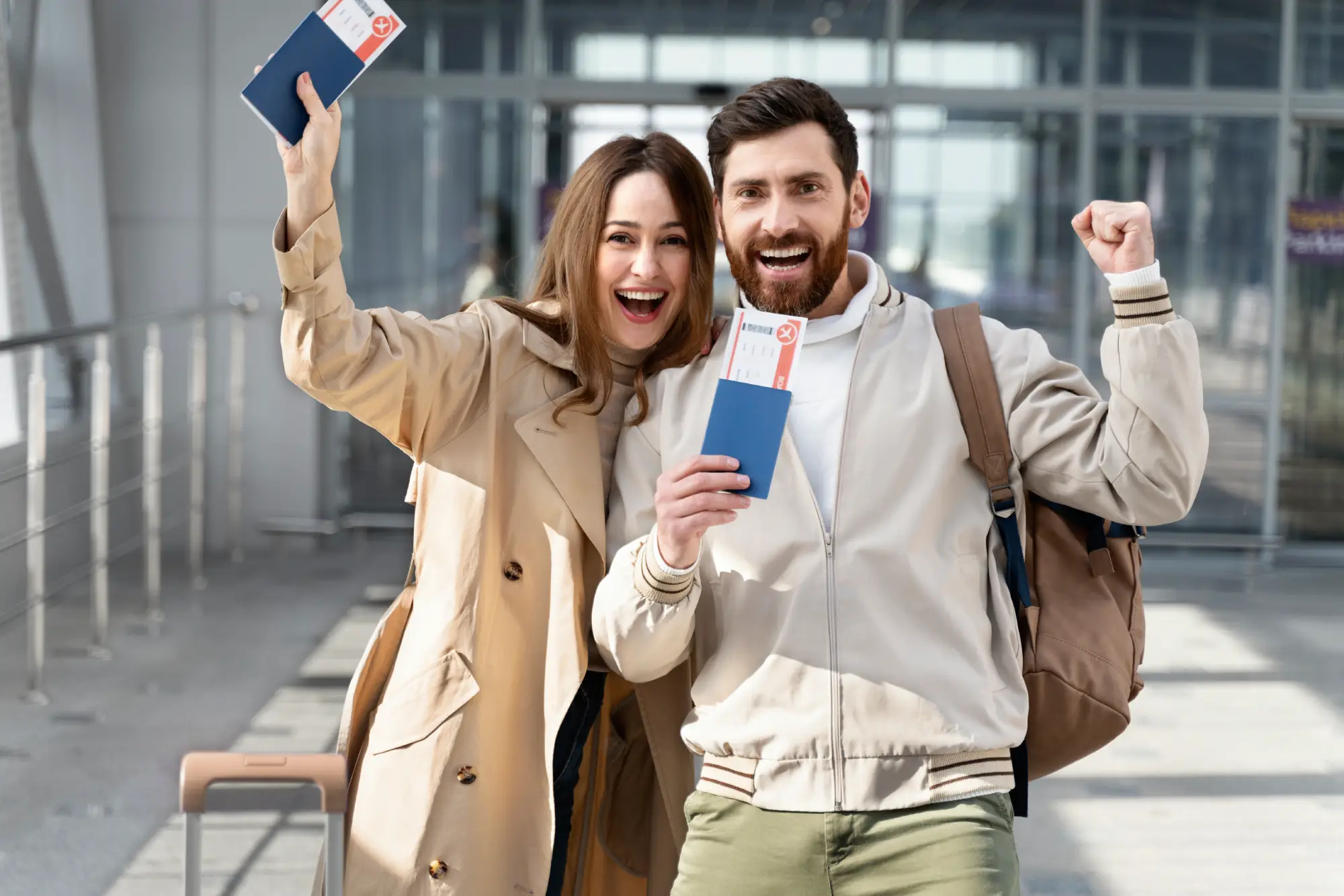 Happy couple holding passports and boarding passes at airport, symbolizing common-law partner sponsorship in Canada immigration