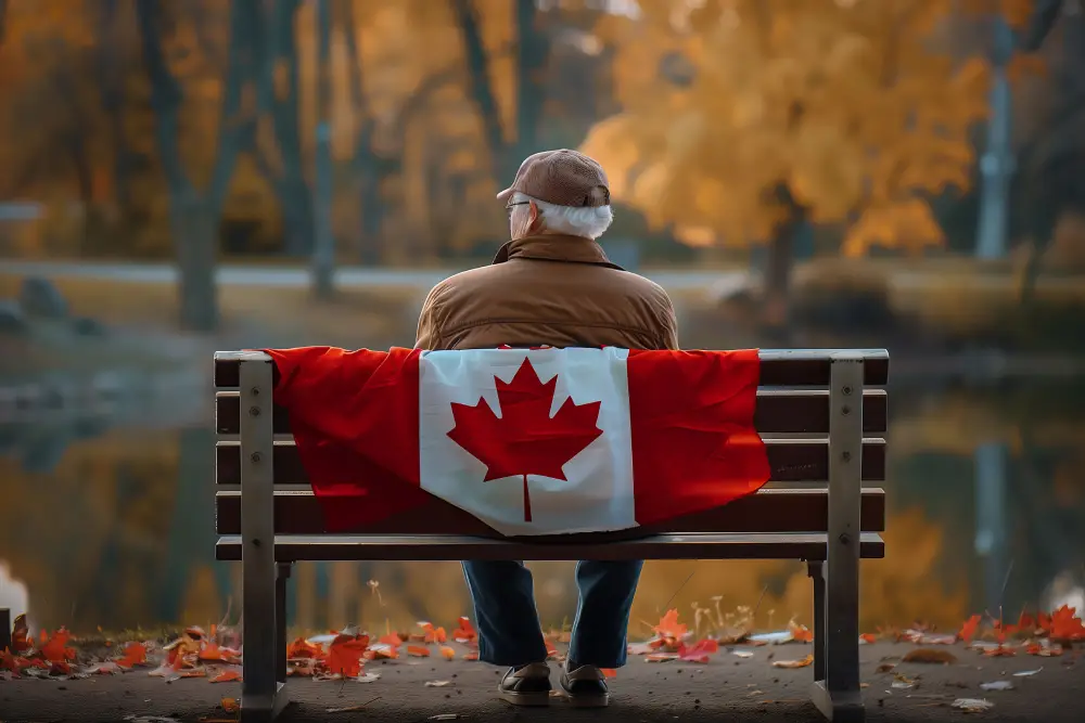 Senior man sitting on bench with Canadian flag, symbolizing exemptions to Canada travel restrictions during COVID-19