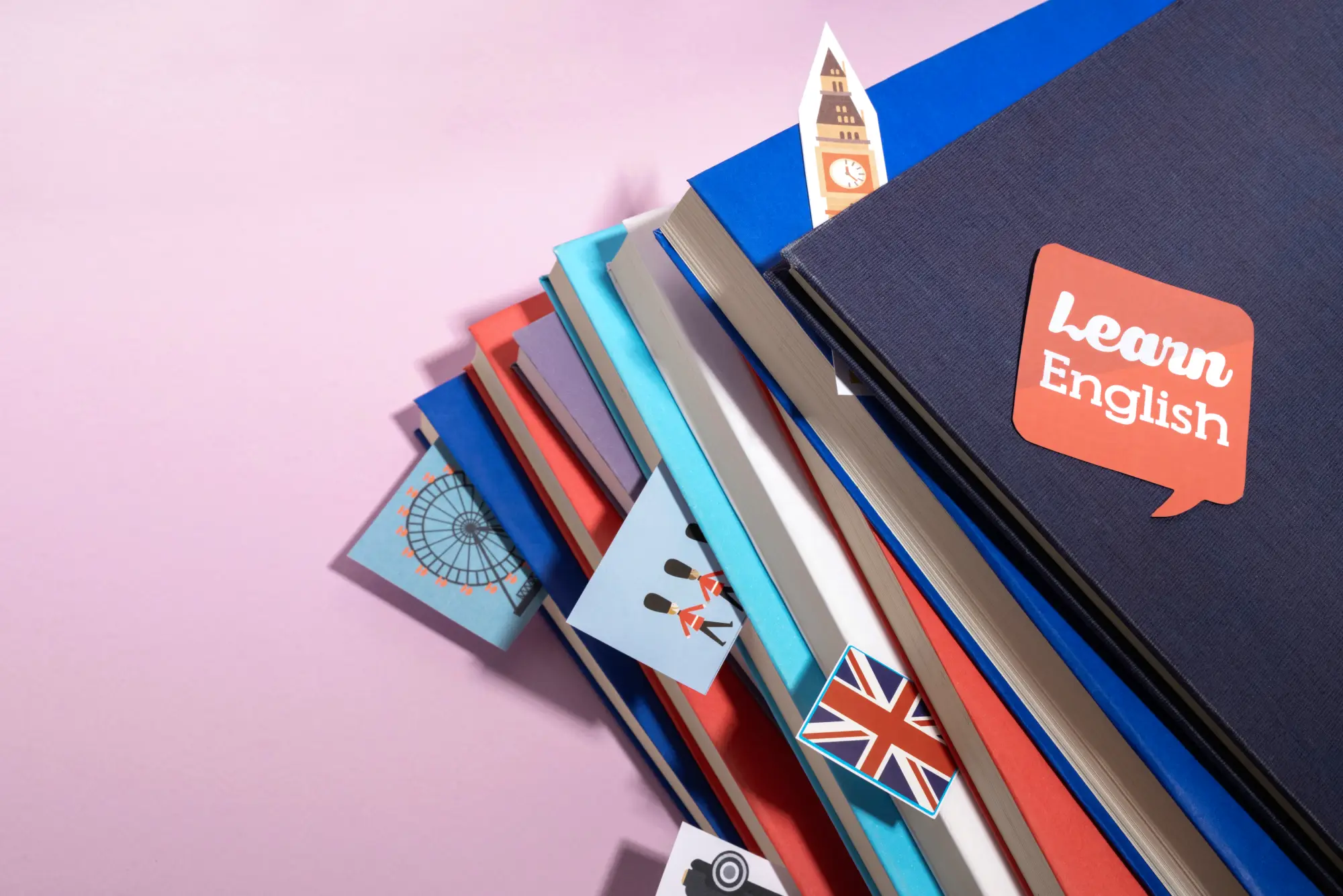 Stack of English learning books with UK-themed icons, representing language proficiency requirements for Canadian immigration programs under CEC and FSTC