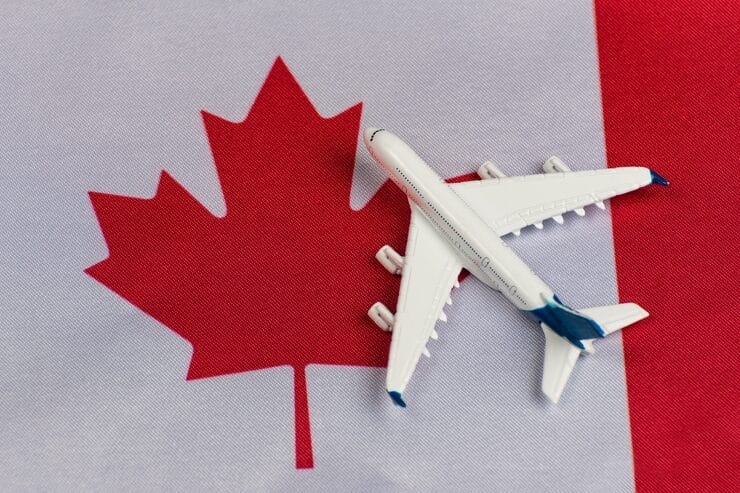 Model airplane on Canadian flag representing travel benefits of permanent residency in Canada