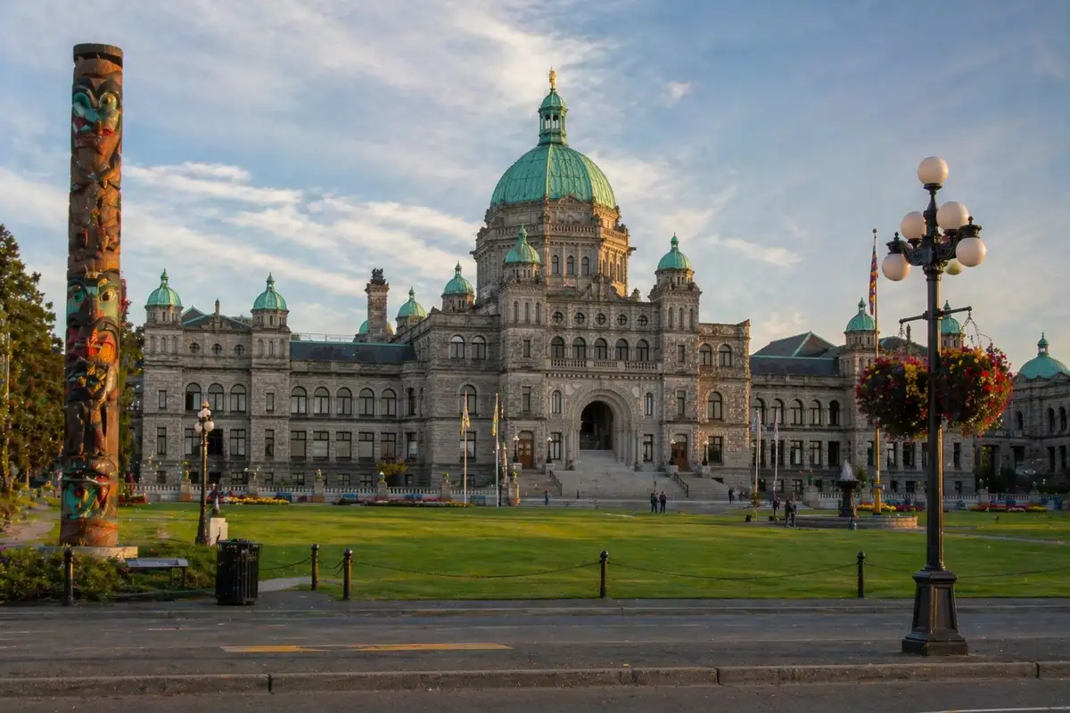 “British Columbia Parliament Buildings in Victoria with green lawn and historic architecture at sunset”