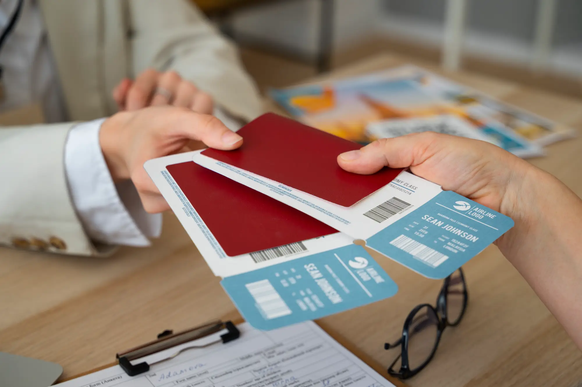 Close-up of hands exchanging passports and airline tickets, representing Temporary Resident Visa for Canada